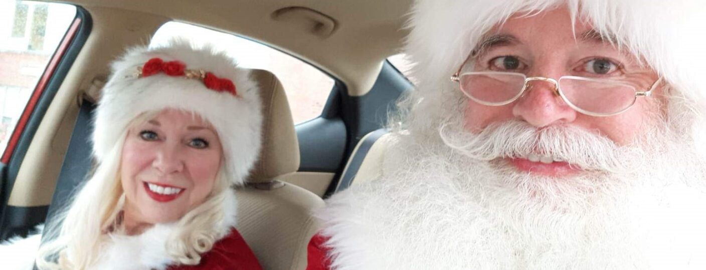 A selfie photo of Santa and Mrs. Claus sitting in a car.